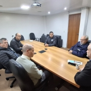 CRM em uma sala de reuniões. Todos estão sentados ao redor de uma mesa retangular, vestidos de forma formal ou com uniformes que remetem à atividade profissional. Os representantes sindicais demonstram expressão atenta e engajada, enquanto os diretores da CRM mantêm postura séria e profissional. 